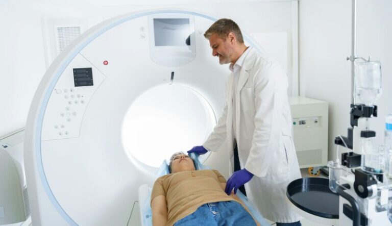 Doctor and female patient in the room of computed tomography at hospital. Healthcare concept